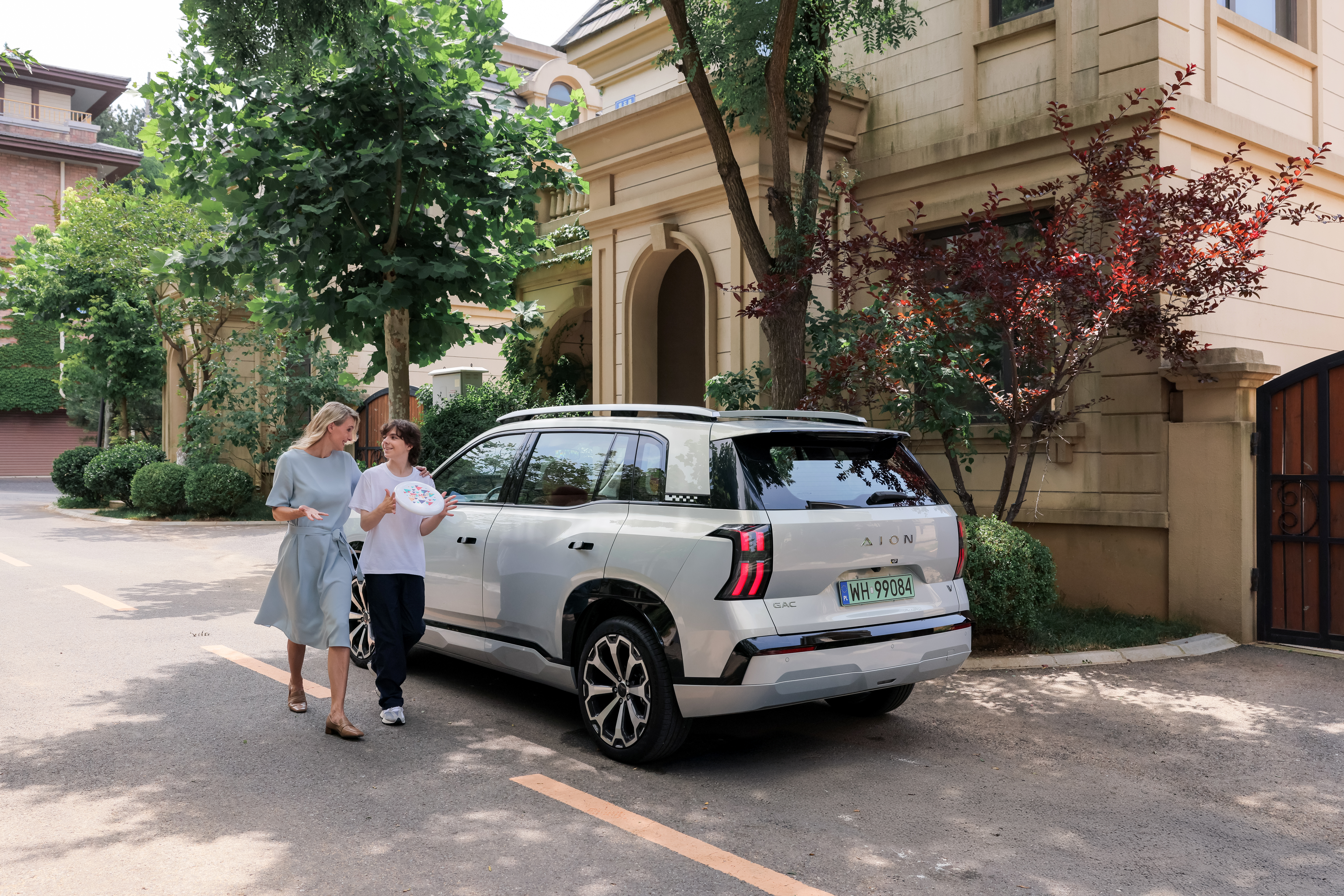 משפחה לצד רכב חשמלי AION