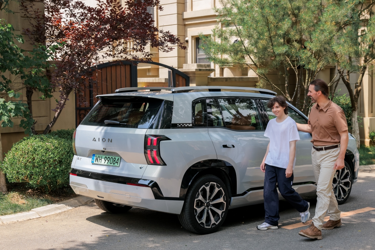 משפחה צועדת לצד רכב חשמלי